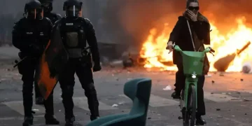 صورة هوليوودية بباريس لزوجين يحتسيان مشروبهما بدم بارد وسط ألسنة النيران المشتعلة